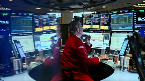 متداول في بورصة وول ستريت يرتدي سترة حمراء، محاط بشاشات تعرض بيانات السوق، يعبر عن القلق بشأن مستقبل الذكاء الاصطناعي.