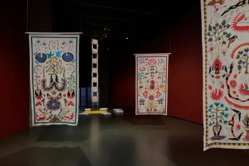 أعمال سيترا ساسميتا تُظهر مجموعة من اللوحات التقليدية المعلقة، تعكس قصصًا عن الأنوثة والتحدي الأسطوري في بيئة فنية حديثة.