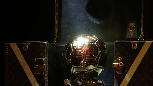 كرة ذهبية لامعة معروضة في علبة فاخرة، تمثل جائزة Ballon d'Or لعام 2026 في كرة القدم العالمية.
