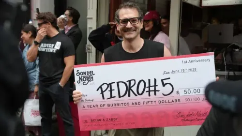 جورج غونتاس يحمل شيكًا كبيرًا بقيمة 50 دولارًا وجائزة سنة من البوريتو المجاني بعد فوزه بمسابقة شبيه بيدرو باسكال في مطعم "سون ديل نورث" في بروكلين.