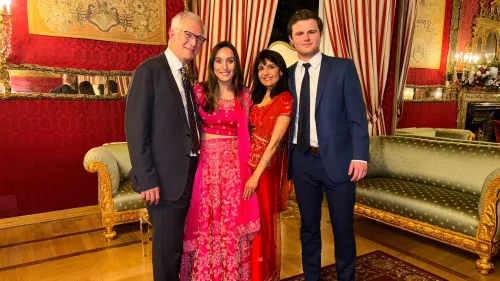 صورة لعائلة مكونة من أربعة أفراد، يرتدون ملابس أنيقة، في مكان مزين بألوان دافئة. تعكس اللحظة روح الاحتفال والتواصل الأسري.