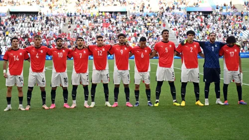 لاعبو منتخب مصر الأولمبي مصطفون قبل مباراة كرة قدم في أولمبياد باريس 2024، يرتدون الزي الأحمر والأبيض الرسمي.