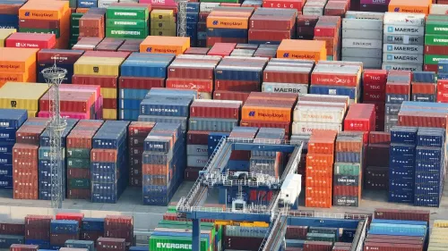صورة تظهر حاويات شحن ملونة في ميناء، تعكس تأثير الرسوم الجمركية الجديدة بين الصين والولايات المتحدة على التجارة العالمية.