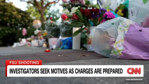 تظهر الصورة زهوراً وأضواءً تذكارية موضوعة على الأرض في موقع حادث إطلاق نار بجامعة ولاية فلوريدا، حيث يُحقق المحققون في دوافع الجريمة.