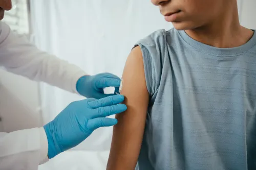 طفل يتلقى لقاح فيروس الورم الحليمي البشري (HPV) من طبيب، مما يعكس أهمية التطعيم للوقاية من السرطانات المرتبطة بالفيروس.