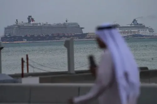 سفينة سياحية كبيرة تبحر في مياه الخليج، بينما يسير رجل يرتدي الزي التقليدي بالقرب من الشاطئ، مما يعكس التفاعل بين السياحة والثقافة المحلية.