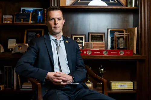 النائب جاريد غولدن يجلس في مكتبه مع خلفية تضم جوائز وصور، يعكس دوره كديمقراطي في مجلس النواب.