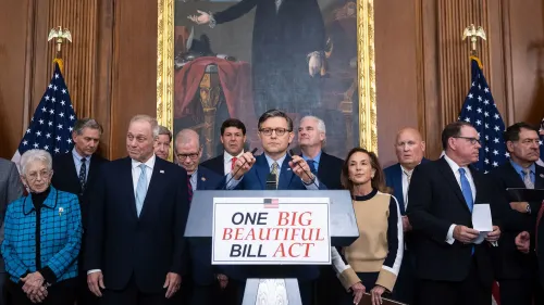 مؤتمر صحفي لعدد من أعضاء الكونغرس الأمريكي، حيث يتحدث أحدهم عن مشروع قانون "واحد كبير وجميل"، مع العلم الأمريكي في الخلفية.