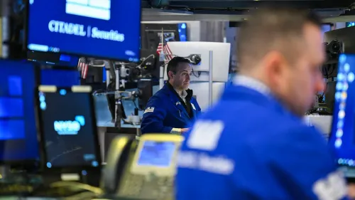 تظهر الصورة مجموعة من المتداولين في بورصة نيويورك، مع شاشات تعرض بيانات السوق، مما يعكس التقلبات الحالية في الأسواق المالية.