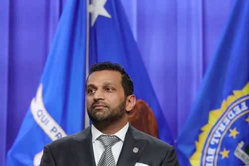 تظهر الصورة Kash Patel، صديق مدير مكتب التحقيقات الفيدرالي، أثناء مؤتمر صحفي، مع أعلام FBI خلفه. تتعلق الأحداث بتقرير صحفي يثير الجدل حول التحقيقات.