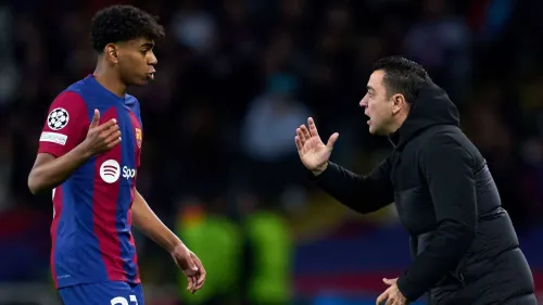 تشافي يتحدث مع لامين يمال لاعب برشلونة الشاب خلال مباراة دوري أبطال أوروبا، مع التركيز على موهبته الاستثنائية ومستقبله الواعد.