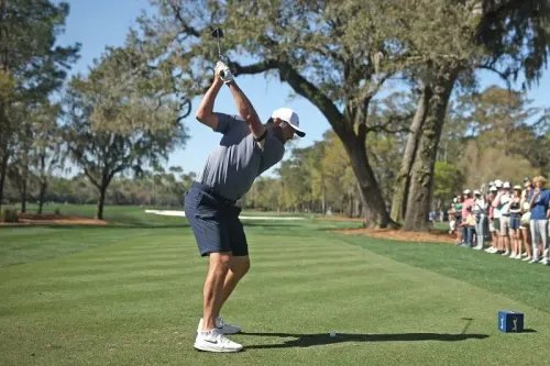 سكوتي شيفلر يستعد لضرب الكرة في بطولة TPC Sawgrass، مع حضور جماهيري في خلفية المشهد، حيث يسعى لتحقيق إنجاز تاريخي في الجولف.