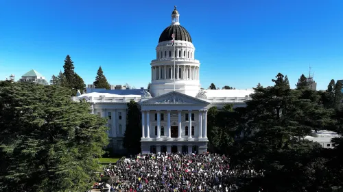 مظاهرة حاشدة أمام مبنى حكومي كبير تحت سماء زرقاء، حيث يجتمع المتظاهرون حاملين لافتات تعبر عن مطالبهم المتعلقة بالتنوع والمساواة.