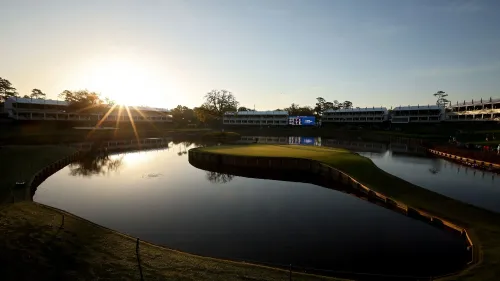 ملعب TPC Sawgrass عند غروب الشمس، مع الحفرة 17 الشهيرة والجزيرة الخضراء، تعكس المياه المحيطة جمال المنظر وتبرز أهمية الملاعب في لعبة الجولف.