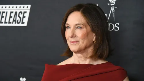 كاثلين كينيدي، رئيسة شركة لوكاسفيلم، تظهر بابتسامة في حدث رسمي، مع خلفية تحمل شعار الشركة، وسط شائعات حول تقاعدها.