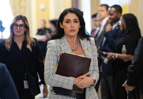 النائبة آنا بولينا لونا تحمل ملفًا وتظهر في ممرات الكونغرس، تعبر عن تصميمها على دفع تشريع لحظر تداول الأسهم للمشرعين.