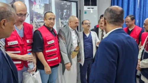 مجموعة من الأطباء والمساعدين الصحيين يتبادلون الحديث في مركز طبي بتعز، حيث يتم إجراء عمليات جراحية للأطفال لعلاج أمراض القلب.