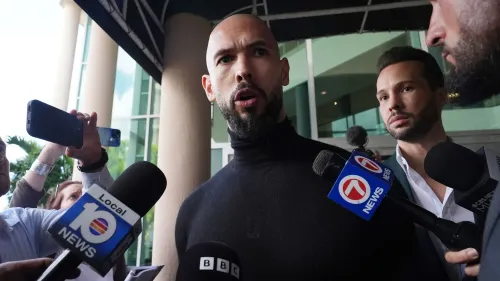 أندرو تيت يتحدث للصحفيين في فلوريدا، محاطًا بمراسلين، بعد مغادرته رومانيا وسط اتهامات بالاتجار بالبشر.