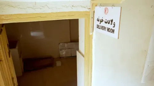 غرفة ولادة في مستشفى بأفغانستان، تظهر لافتة "غرفة الولادة" على الجدار، تعكس الظروف الصعبة للرعاية الصحية في البلاد.