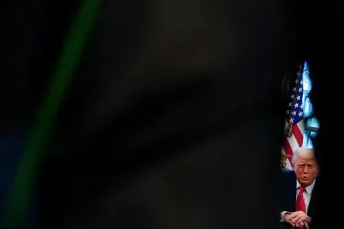ترامب يجلس في غرفة مظلمة، مع العلم الأمريكي خلفه، في سياق تصاعد التوترات التجارية بين الولايات المتحدة والصين.