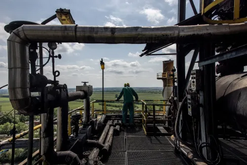 عامل في منشأة صناعية يراقب خطوط الأنابيب في مشهد يعكس تأثير التجارة العالمية مع روسيا في ظل الأزمات الحالية.