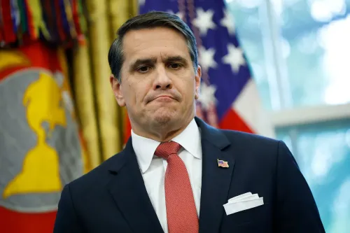 إد مارتن، نائب المدعي العام المساعد، يظهر في مؤتمر صحفي، مع العلم الأمريكي خلفه، مع تعبير جاد يعكس سلطته المتزايدة في وزارة العدل.