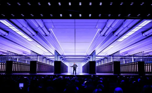 مؤسس إنفيديا، جينسن هوانج، يتحدث في مؤتمر الذكاء الاصطناعي GTC، مع خلفية تكنولوجية متطورة وإضاءة زرقاء.