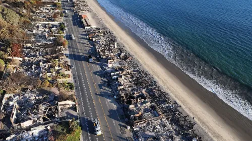 مشهد جوي لشارع بجانب الشاطئ، يظهر آثار حريق مدمر حيث دمرت المنازل بالكامل، مع بقايا الرماد والأشجار المحترقة.