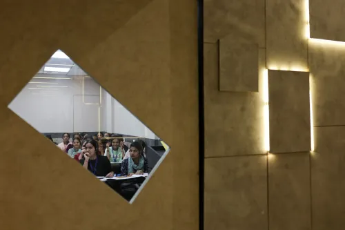 مجموعة من الطالبات في فصل دراسي يتابعن الدروس بتركيز، تعكس الصورة التحديات التي تواجه الطلاب الهنود في الحصول على تأشيرات للدراسة في الولايات المتحدة.