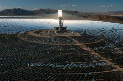 محطة إيفانباه للطاقة الشمسية في صحراء موهافي، تظهر فيها المرايا التي تركز أشعة الشمس على الأبراج العالية، مع خلفية جبال.