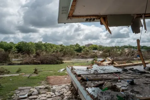 منظر داخلي لمنزل مدمر بعد الفيضانات في تكساس، يظهر الأثاث المتضرر والخراب المحيط، مع غيوم داكنة في السماء.