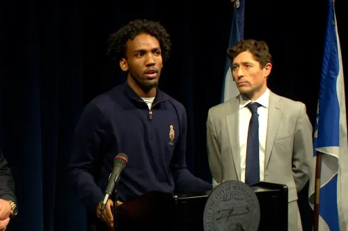 مبشر يتحدث في مؤتمر صحفي، مع وجود مسؤول بجانبه، حول تجربة احتجازه من قبل عملاء فيدراليين في مينيابوليس.