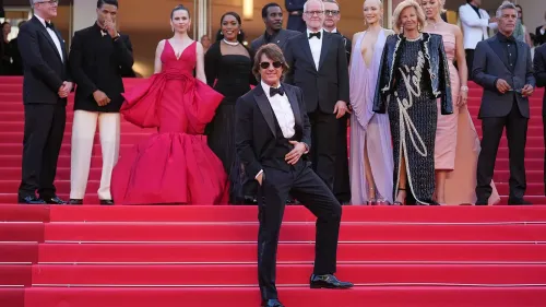توم كروز يقف مبتسمًا على السجادة الحمراء في مهرجان كان، محاطًا بفريق عمل فيلم "Mission: Impossible - The Final Reckoning".