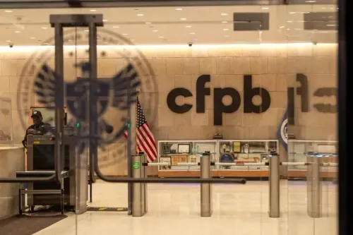 مدخل مكتب الحماية المالية للمستهلكين (CFPB) مع شعار الوكالة، حيث يظهر موظف أمن خلف نقاط التفتيش.