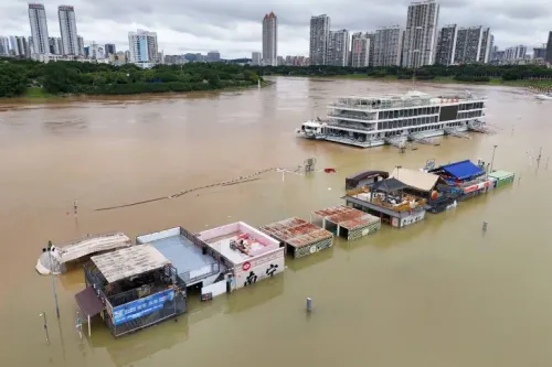 مباني ومطاعم غارقة في فيضان نهر Guangxi وسط الصين بعد الأمطار الغزيرة وإعصار Maysak، مع أضرار واسعة ونزوح السكان.