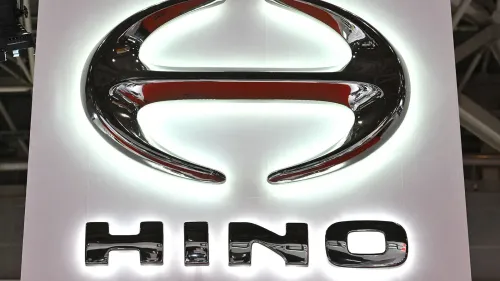 شعار شركة هينو موتورز مضاء، مع التركيز على التصميم الأنيق والحديث، في سياق تسوية الشركة بشأن انبعاثات محركات الديزل.