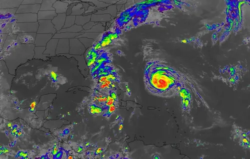 تظهر الصورة خريطة للأقمار الصناعية توضح موقع العاصفة الاستوائية إيميلدا وإعصار هامبرتو في المحيط الأطلسي، مع تباين الألوان للدلالة على قوة العواصف.