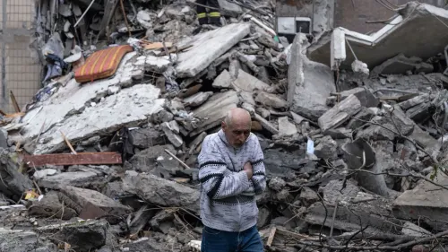 رجل مسن يتجول بين أنقاض مبنى مهدوم، يعكس آثار الصراع في أوكرانيا وتأثيره على المدنيين.