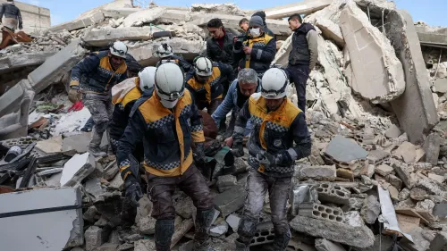 متطوعون من منظمة الخوذ البيضاء يعملون في موقع انهيار مبنى في سوريا، يقدمون المساعدة للمدنيين المتضررين من النزاع.