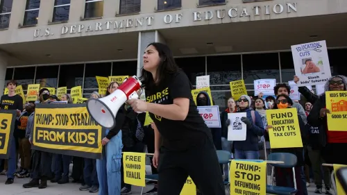 محتجون أمام وزارة التعليم الأمريكية يحملون لافتات تدعو إلى تمويل التعليم ووقف تخفيضات الميزانية، خلال مظاهرة ضد إدارة ترامب.