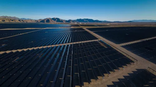 مصفوفات شمسية واسعة في صحراء نيفادا، تمثل مشروع إزميرالدا 7 للطاقة الشمسية، الذي أُلغي مؤخرًا، مع تأثيرات بيئية واقتصادية ملحوظة.