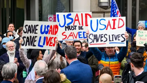 احتجاجات أمام مبنى حكومي، حيث يحمل المتظاهرون لافتات تطالب بإنقاذ وكالة التنمية الدولية الأمريكية (USAID) ودعم حقوق الإنسان.