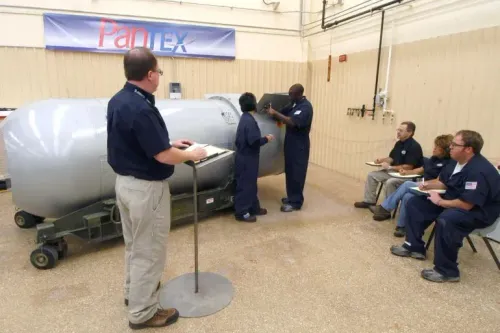 مجموعة من العاملين في وكالة الأمن النووي الأمريكية يتدربون على صيانة الأسلحة النووية في منشأة بانتيكس، مع وجود مشرف يقوم بتدوين الملاحظات.