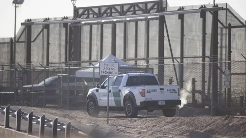 سيارة دورية تابعة لحرس الحدود الأمريكي بالقرب من سياج حدودي، تشير إلى تكثيف جهود اعتقال المهاجرين غير الشرعيين في الولايات المتحدة.