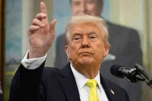 ترامب يتحدث في مؤتمر صحفي، مشيرًا بيده، مع صورة خلفية له. يناقش قضايا تتعلق بفنزويلا وعمليات الاستخبارات.