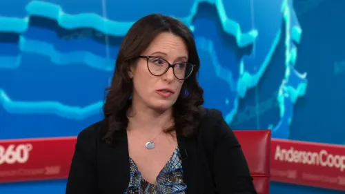 امرأة ترتدي نظارات وتظهر في مقابلة تلفزيونية، تتحدث عن قضايا قانونية تتعلق بإدارة ترامب، مع خلفية توضح الرسوم البيانية.