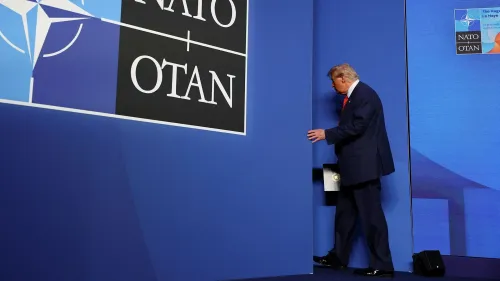 ترامب يغادر منصة مؤتمر حلف شمال الأطلسي، مع شعار الناتو خلفه، بعد انتقاده لرئيس الاحتياطي الفيدرالي جيروم باول.