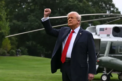 رجل يرتدي بدلة رسمية وقميصًا أحمر، يرفع يده بإشارة القوة أمام مروحية، مما يعكس موقفه القوي بشأن قضايا الجيش والحرب.