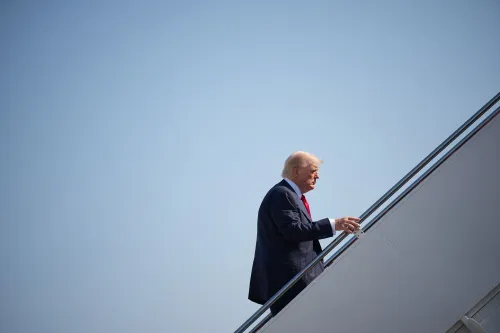 دونالد ترامب يصعد إلى الطائرة، يعكس التوتر السياسي الحالي والجدل حول نظريات المؤامرة وتأثيرها على الحكومة الأمريكية.