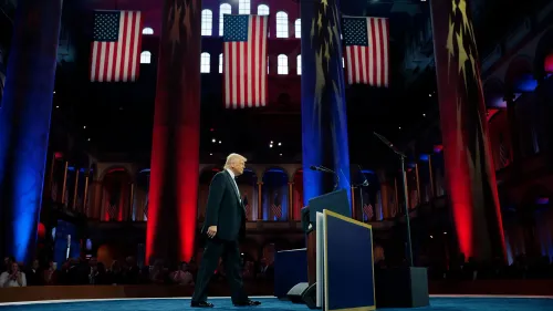 ترامب يتجه نحو المنصة في حفل عشاء للجنة الوطنية للحزب الجمهوري، مع أعلام أمريكية تتدلى من الأعمدة.